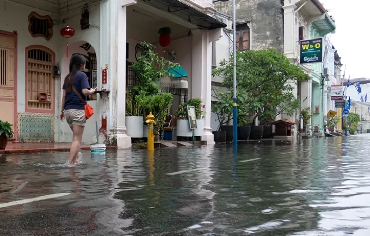 Woman walking through flood waters in Malaysia