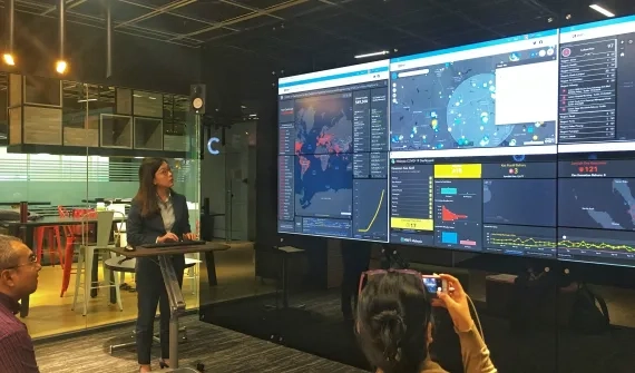 Joanne Loh in front of contact tracing dashboards