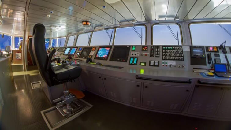 The bridge of a modern cargo ship with various electronic inputs